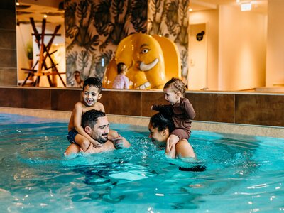 Eltern spielen mit Kindern im Wasser