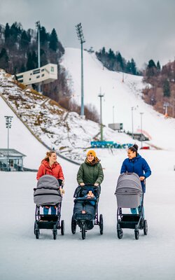 Drei Mütter mit Kinderwagen im Winter