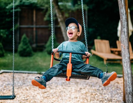 Kind schaukelt am Spielplatz