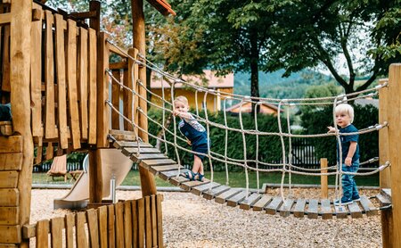 Jungen klettern am Spielplatz des Hotels