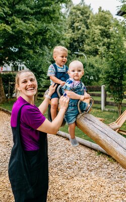 Kinder auf der Wippe am Spielplatz