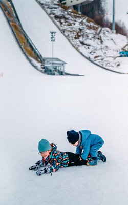 Kinder auf der Wippe am Spielplatz