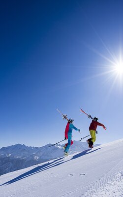 Pärchen tragt Ski auf den Berg